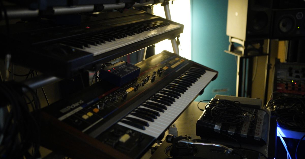 Close-up of vintage keyboard synthesizers in music studio setting, ideal for music production.